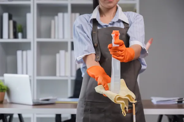 Tecnico Spaziclean desinfectando superficies de escritorio en oficina comercial